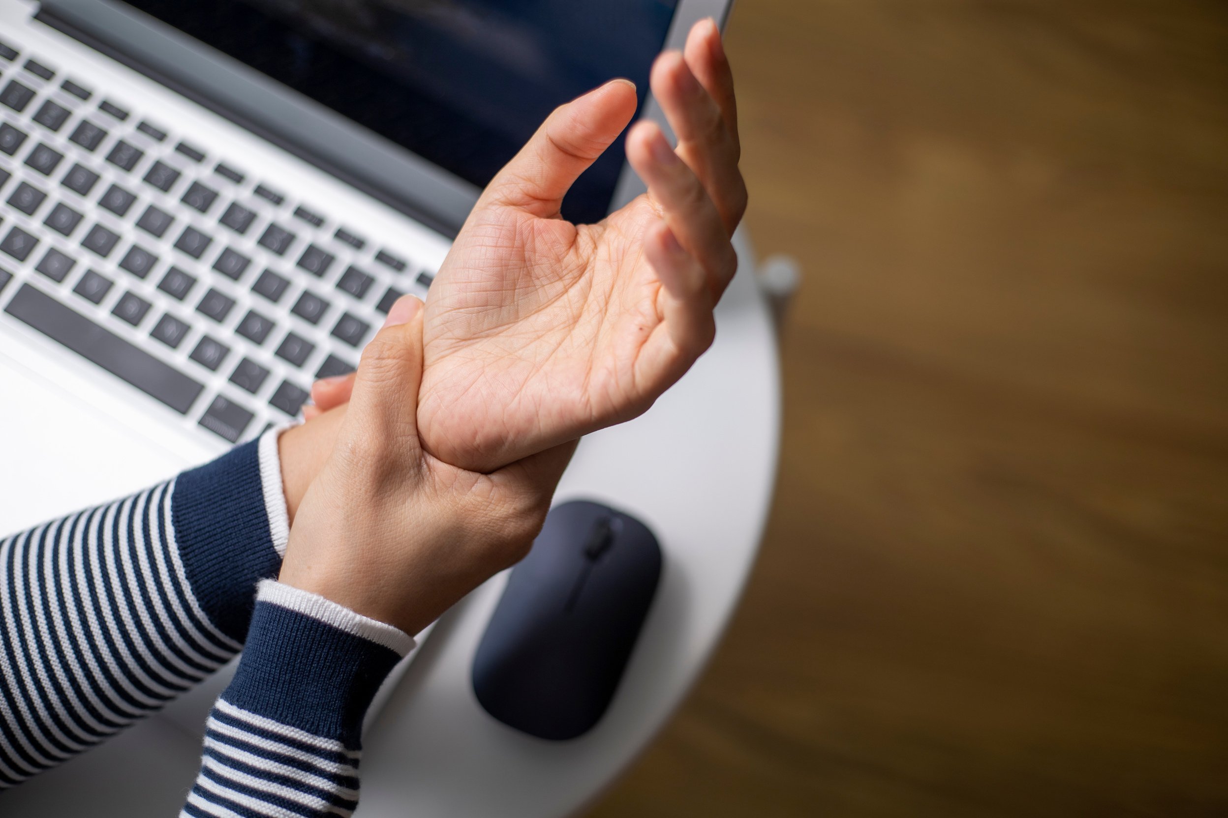 Woman massaging painful wrist at work repetitive strain injury